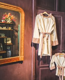 Soft, plush white bathrobe with a belted waist and long sleeves. Ideal for relaxing at home or after a bath.