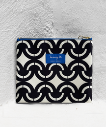 A large black and white patterned clutch bag with a zipper closure.