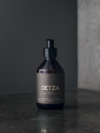 Moisturizing hand sanitizer in a sleek, dark bottle with the brand name "DETZA" printed on it. The sanitizer is designed to clean and hydrate hands without drying them out.