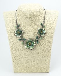 Metal flower necklace with hematite plating, featuring a statement floral design with green gemstones.