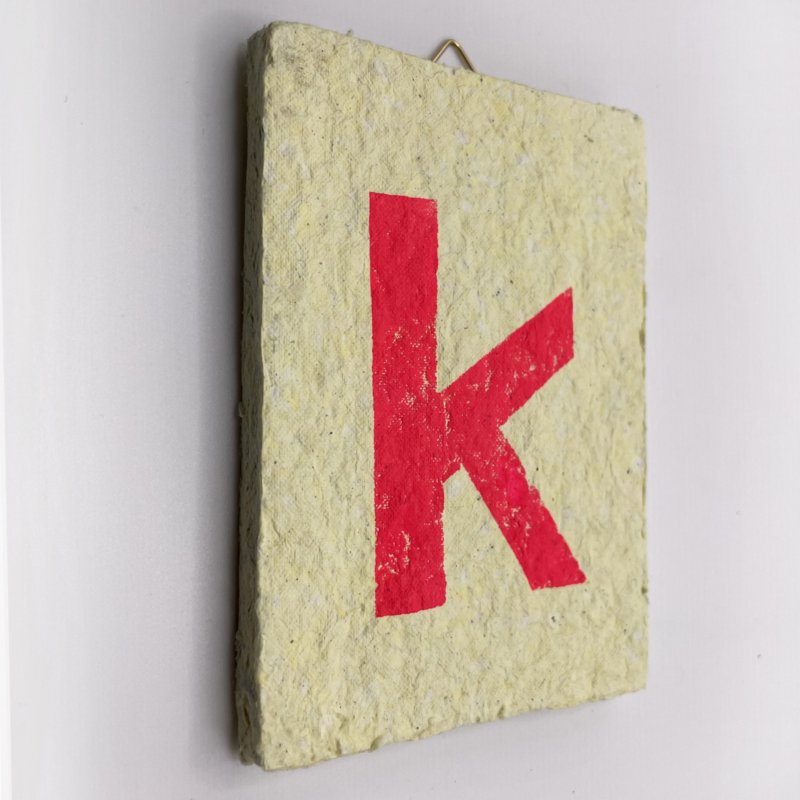 Letter -  roze letter op gele tegel