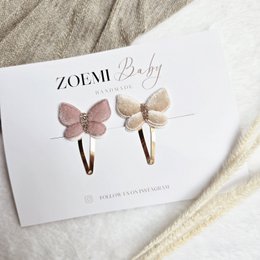  Peach and white butterfly-shaped barrettes with a delicate floral design, suitable for kids' hair accessories.