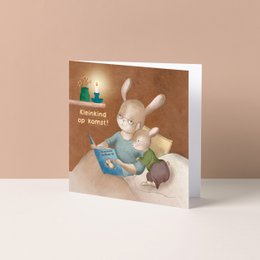  A greeting card featuring a cute baby animal character reading a book, with shelves displaying decorative items in the background.