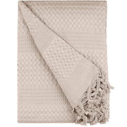 Beige waffle-textured bedspread with tasseled edges, suitable for a cozy bedroom.