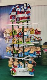 Hand-painted wooden birdhouse display, round stacked tower, colorful bird designs, white green variants, decorative.