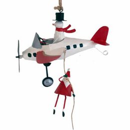  A whimsical ornament depicting a small red gnome figure descending with a parachute. The parachute is blue and white in color, creating a striking contrast against the red gnome. This ornament would make a charming addition to any holiday decor.