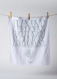 White and green tea towel with a floral design and the text "Fresh dill, parsley, thyme, rosemary, basil, oregano".