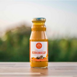 Pure turmeric juice in a 200ml glass bottle. Vibrant orange color. Turmeric tea, turmeric shot, or turmeric drink.