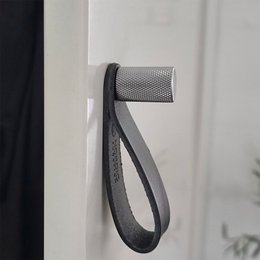 Chrome-look coat rack with leather strap, suitable for hanging coats, jackets, or other items.