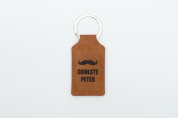  Leather keychain with "Coolest Peter" text, rectangular shape, brown color, metal ring for attaching to keys.