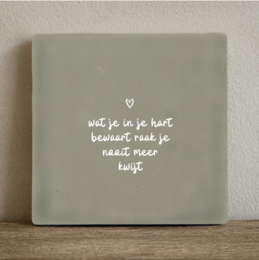 A 10x10 cm tile with the text "wat je in je hart bewaart, blijft je altijd bij" (what you keep in your heart, stays with you forever) written on it in a simple, handwritten style.