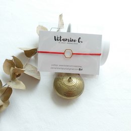 Red charm bracelet with gold-colored charm