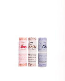 A set of three moisturizing lip balms in different flavors - Morango, Côco, and Cacau. The lip balms come in a refillable format, allowing for easy replacement of the product. The packaging features the product names in a stylized font.