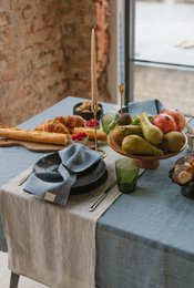 Natural linen table runner in melange colors, suitable for a rustic or farmhouse-style table setting. Features a mix of neutral tones and natural fibers.