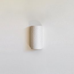 Elegant, minimalist white ceramic wall sconce with up and down lighting for a Japandi-inspired look.