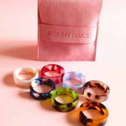 Colorful acrylic rings in various styles and shapes, including round, oval, and abstract designs. The rings feature a range of vibrant colors such as brown, cream, white, navy blue, green, pink, and red.