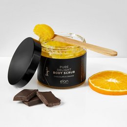 A luxurious chocolate and orange-scented body scrub in a glass jar with a wooden spoon. The scrub contains natural exfoliating ingredients to gently remove dead skin cells and leave skin feeling soft and nourished.