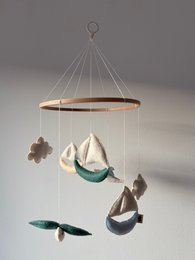  "Hanging baby mobile with sailboats, fish, and nautical theme in cream, teal, and brown colors"