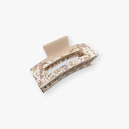 Rectangular beige hair clip made of resin material with a textured surface.