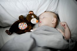 Soft, plush comforter in a neutral color, perfect for cuddling and relaxing. Includes a cozy stuffed animal companion.