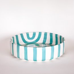 Large mint green striped bowl, wide shallow shape, vertical and curved stripe pattern, ceramic.