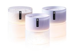 Scented candles in mandarin, elemi, and grapefruit fragrances. Cylindrical shape with white and lavender color variants.
