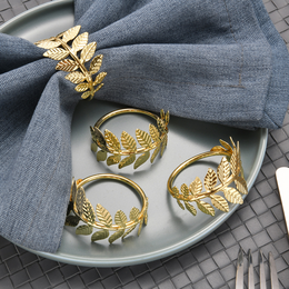  Small round napkin rings with silver or golden leaf designs, suitable for formal or casual dining settings.