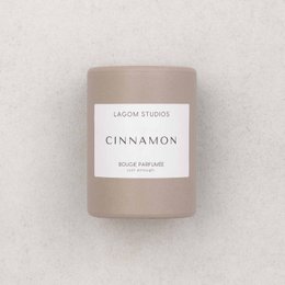 Tall, round, brown and beige scented candle with cinnamon fragrance.