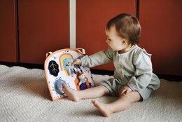 Colorful activity board with various shapes, textures, and interactive elements. Suitable for young children's development and play.
