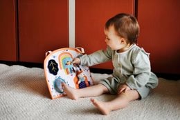 Colorful activity board with various shapes, textures, and interactive elements. Suitable for young children's development and play.