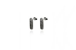 Long, round stud earrings made of a textured, dark metal material.