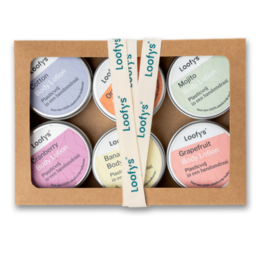 A set of miniature body lotion containers in various pastel colors, packaged in a gift box.
The image shows a set of 6 small body lotion containers in a gift box. The containers are in various pastel colors such as pink, blue, and white. The containers appear to be made of plastic or a similar material. The gift box is made of cardboard and has a ribbon tied around it.