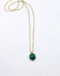Gold necklace with malachite marquise pendant. Elegant and sophisticated jewelry piece.