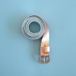 Leather belt with copper buckle, suitable for casual or formal wear.