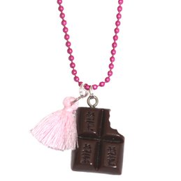 A children's necklace with a chocolate-shaped pendant and a pink tassel charm on a pink beaded chain.