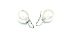 Classic pearl earrings with a simple, elegant design featuring two round, white pearls suspended from silver hooks.