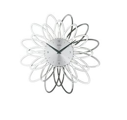 A modern, silver-colored wall clock with a stylized flower design. The clock features a large, open flower shape with multiple petals and a central hub. The design is minimalist and contemporary, making it a visually striking addition to any room.