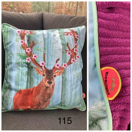 Cushion cover featuring a red deer with antlers against a nature backdrop. The cushion cover is made of soft, plush material in shades of green and red, creating a cozy and rustic aesthetic.