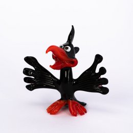 A black glass figurine of a bird with a red beak and feet.