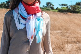 Lightweight, colorful scarf with a vibrant grapefruit print and contrasting red accents. Versatile accessory for casual or formal wear.