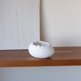 Ceramic Easter egg in white, cream, and mint colors. Egg-shaped with a scalloped design, suitable for Easter decoration.