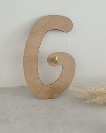 Wooden wall decor with the text "Let's play" in a circular frame, featuring wooden balloon shapes in various sizes.