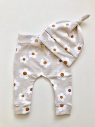 Newborn set with daisy print, featuring soft, comfortable pants in a light, neutral color palette.