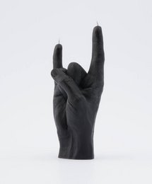 Black candle in a tall, round shape with a rock and roll hand gesture design.