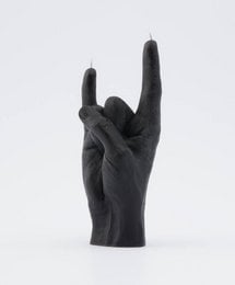 Black candle in a tall, round shape with a rock and roll hand gesture design.