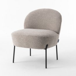 Beige upholstered armchair with black metal legs. Soft, plush fabric in a neutral color. Rounded, curved seat and backrest design for comfortable seating.