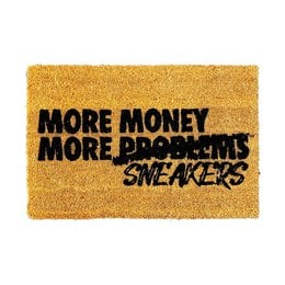 Coconut fiber doormat with text "MORE MONEY MORE SNEAKERS" in black lettering on a yellow background. The doormat is rectangular in shape and appears to be made of natural materials.