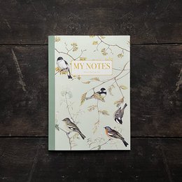 A notebook with a nature-inspired design featuring birds perched on branches with delicate flowers.