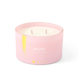 A round, tall pink candle with a yellow accent, packaged in a pink box. The candle is scented and labeled "Mom in a million".