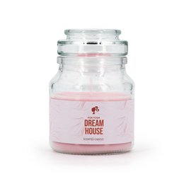 A pink-colored, round, glass candle jar with the text "Dream House" printed on the label. The candle appears to be a scented variety, likely with a floral or sweet fragrance.